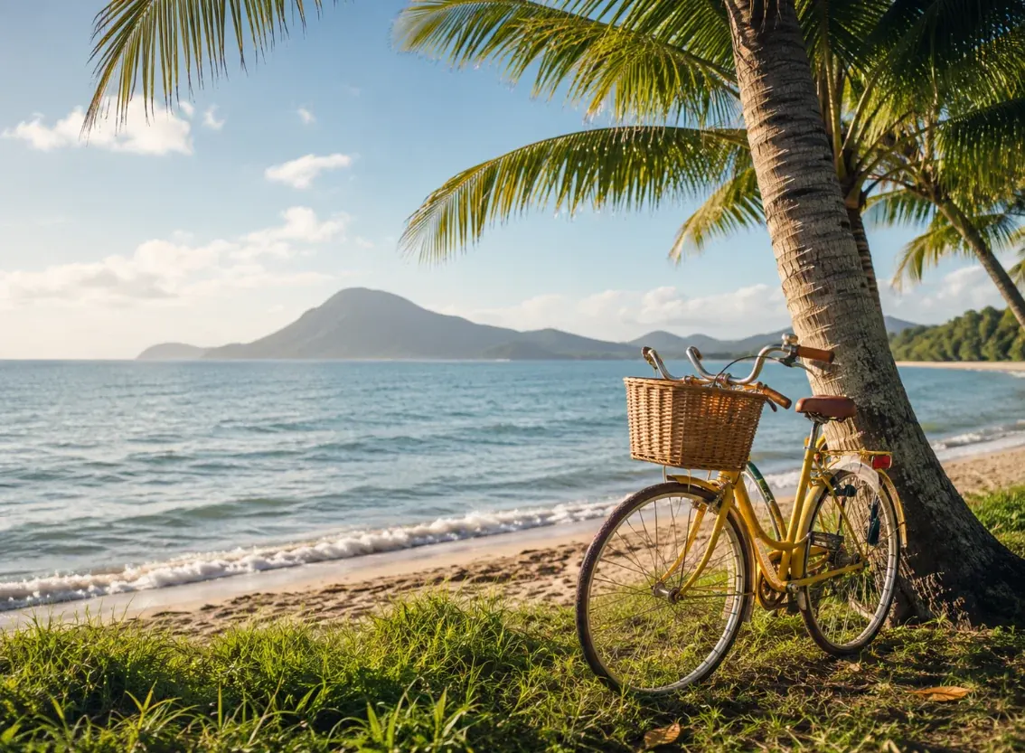 Mission Beach lifestyle — palm-lined beach with Dunk Island and a yellow bicycle